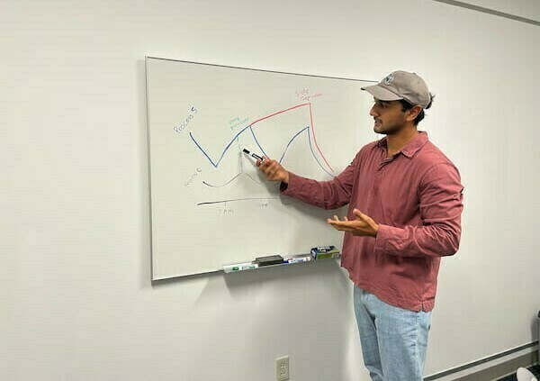 Arash in front of a dry erase board showing the two-process model of sleep regulation