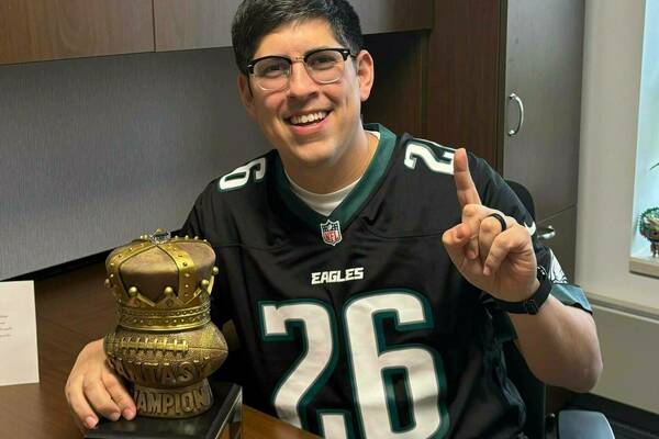 Image of Dr. Vargas posing with the first place trophy for the department fantasy football league.